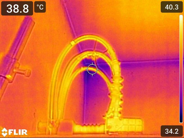 Técnico medindo resistência elétrica em um cabo de aterramento com multímetro, em ambiente externo.